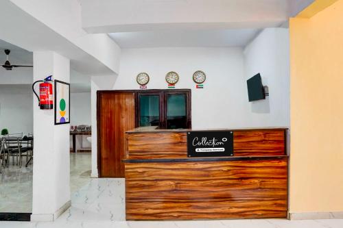 a restaurant with a wooden counter with two clocks on the wall at Super Collection O Matiyari in Lucknow
