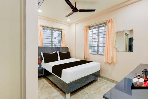 a bedroom with a bed in a room with windows at Townhouse MVP Circle Visakhapatnam in Visakhapatnam