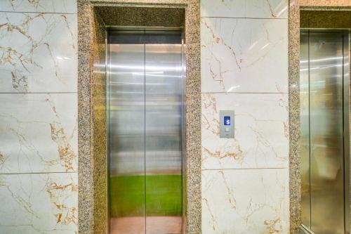 a metal elevator in a building with a green at Townhouse Indore Junction in Indore