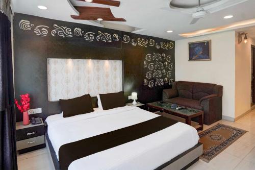 a bedroom with a large bed and a couch at Super Collection O Kanpur in Kānpur