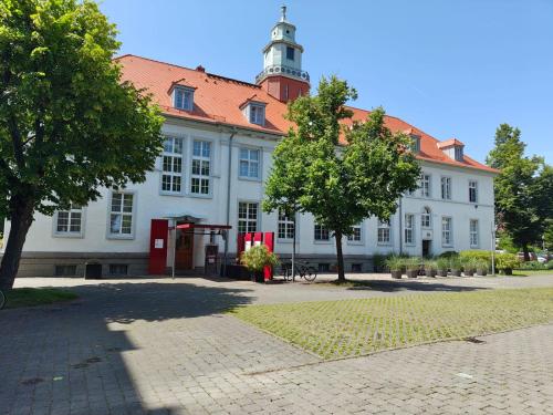 a large white building with a red roof at WHLIVING - Apartments & Studios in Konstanz in Konstanz