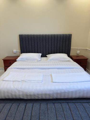 a large bed with a black headboard and two pillows at ركن صحاري للشقق المخدومة العليا Rukn Sahari for Served Apartments in Tabuk