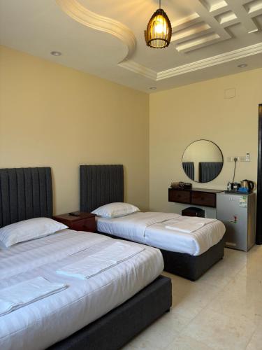 a hotel room with two beds and a mirror at ركن صحاري للشقق المخدومة العليا Rukn Sahari for Served Apartments in Tabuk