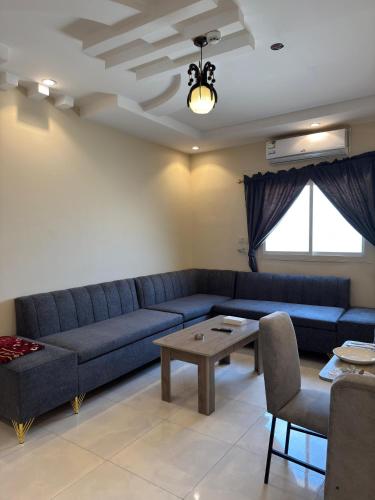a living room with a blue couch and a table at ركن صحاري للشقق المخدومة العليا Rukn Sahari for Served Apartments in Tabuk
