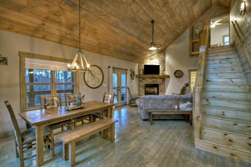 ein Wohnzimmer mit einem Holztisch und einer Couch in der Unterkunft Holly Berry Hill - Walk to Lake Nottely, Unwind in the Hot Tub & Enjoy S’mores Under the Stars in Young Harris