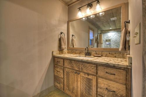 ein Badezimmer mit Waschbecken und Spiegel in der Unterkunft Holly Berry Hill - Walk to Lake Nottely, Unwind in the Hot Tub & Enjoy S’mores Under the Stars in Young Harris