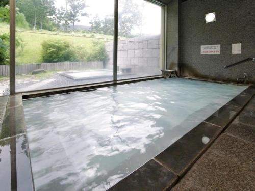 a pool of water in a room with a window at Kuju Kogenso Hotel in Kokonoe