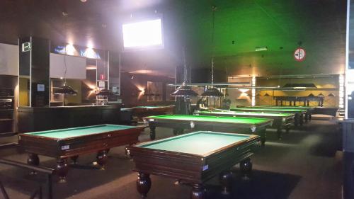 a row of pool tables in a bar with green walls at Hotel Antwerp Billard Palace in Antwerp