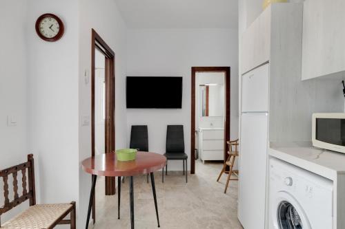 a living room with a table and a kitchen at Juani en Conil in Conil de la Frontera