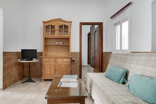 a living room with a couch and a tv at Juani en Conil in Conil de la Frontera