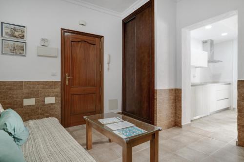 a living room with a table and a wooden door at Juani en Conil in Conil de la Frontera