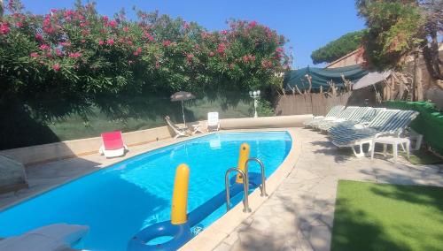- une piscine dans une cour avec 2 chaises longues dans l'établissement Maison Villa d'exception meublée piscine privée & cheminée a 2min plage et commerces, à Marseillan