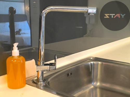 a soap bottle sitting next to a kitchen sink at Almas Couple Relax Modern Comfort Netflix BySTAY in Nusajaya
