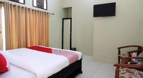 a bedroom with a bed and a flat screen tv at Hotel O Abz Guest House Syariah in Jambi