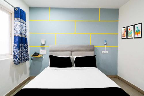 a bedroom with a white bed and blue walls at Collection O Shilparamam Art Village Madhapur in Hyderabad