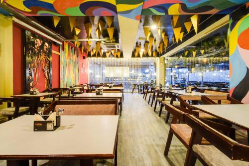 a restaurant with tables and chairs and a colorful ceiling at Collection O Shilparamam Art Village Madhapur in Hyderabad