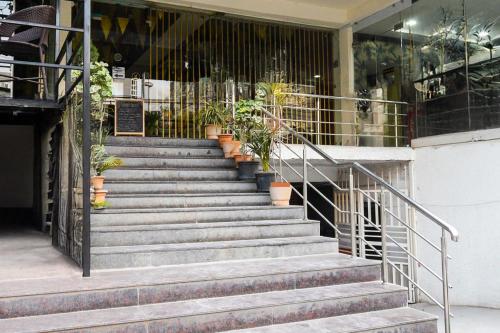 a set of stairs in a building with potted plants at Collection O Shilparamam Art Village Madhapur in Hyderabad