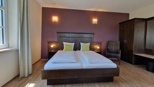 a bedroom with a large bed with two lights on it at Autenrieder Brauereigasthof in Ichenhausen