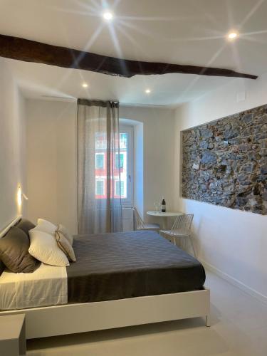 a bedroom with a bed and a stone wall at Mistral in Riomaggiore