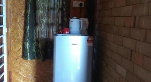 a small refrigerator sitting next to a brick wall at MyDesaStay in Sekincan