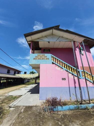 a pink and blue building with a roof at OYO 90302 Dimuara Chalet Tok Bali in Pasir Puteh