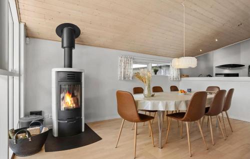 HalsにあるBeautiful Home In Hals With Saunaの暖炉付きのダイニングルーム(テーブル、椅子付)
