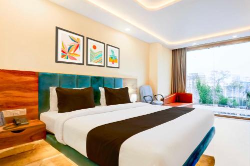 a bedroom with a large bed and a large window at Townhouse Oak City Centre Dhanbad in Dhanbād