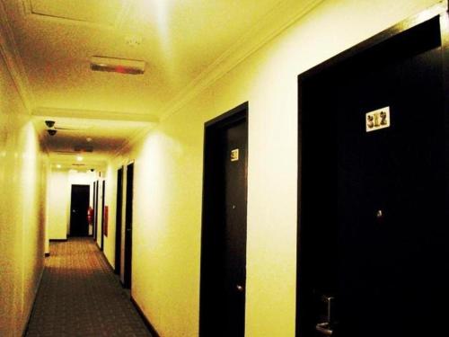 a corridor of a hallway withexit signs on the walls at Adel Hotel in Kota Kinabalu