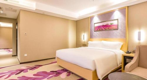a bedroom with a large white bed and a desk at Lavande Hotel Langfang Xianghe in Langfang