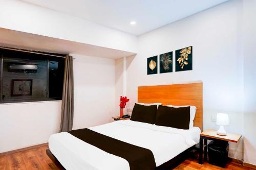a bedroom with a large white bed and a window at Townhouse Oak Nagpur Railway Junction Empress Mall in Nagpur