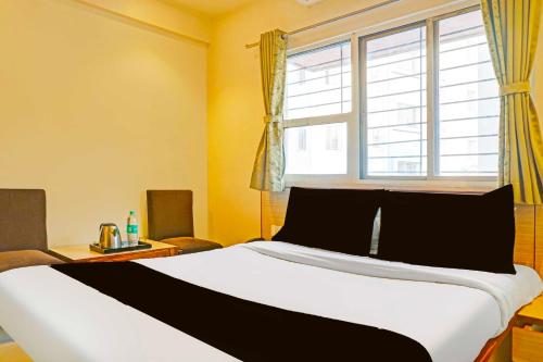 a bedroom with a large bed with a window at Collection O Pune Nagar Road Viman Nagar in Pune