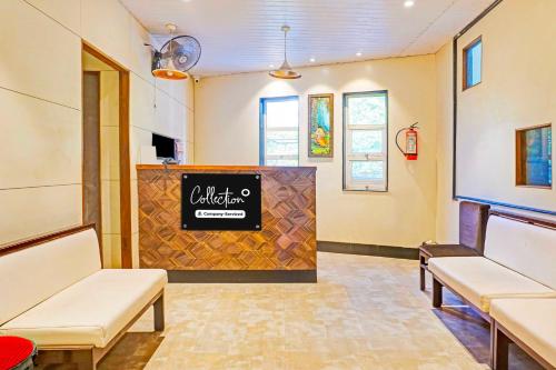 a waiting room with two white chairs and a sign at Collection O Pune Nagar Road Viman Nagar in Pune