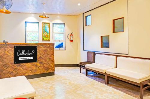 a waiting room with white chairs and a sign at Collection O Pune Nagar Road Viman Nagar in Pune