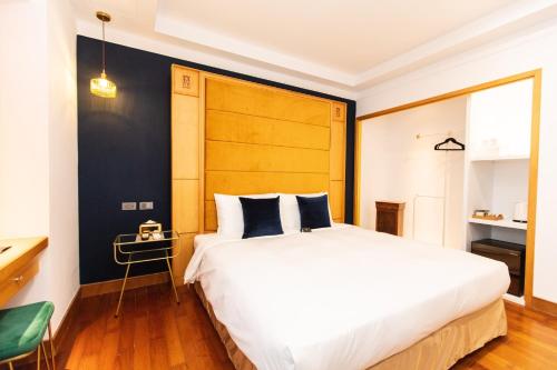 a bedroom with a large white bed with a wooden headboard at 旅行博物館 Hôtel du Musée in Taitung City