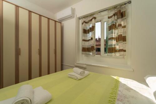 a bedroom with two towels on a bed with a window at Piazza dei Signori in Zadar