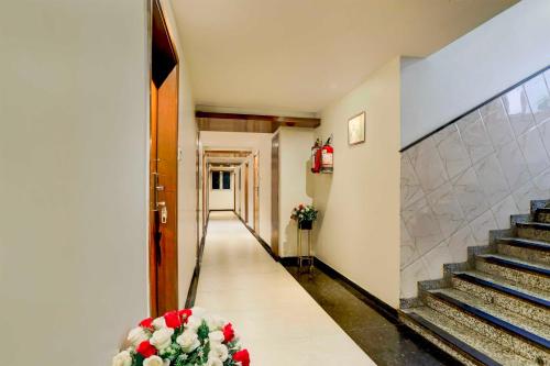 a hallway with stairs and flowers in a building at Townhouse Oak Ahmedabad Junction in Ahmedabad