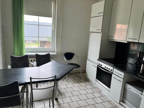a kitchen with a table and chairs and a window at Dähre Wohnung 3 in Niederdorla