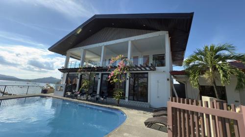 a house with a swimming pool in front of a house at Whiterock Beach Hotel and Waterpark in Subic