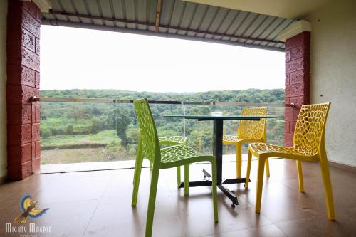 a table and chairs on a balcony with a view at Khushi Riverside Resort & Spa in Mahabaleshwar