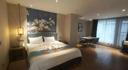 a hotel room with a large bed and a table at Magnotel Shenyang Consulate Qingnian Street in Shenyang