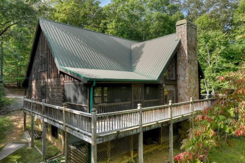a log cabin with a metal roof and a chimney at Buffalo Ridge Fish in the pond soak in the hot tub in Mineral Bluff