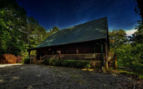 a building with a green roof under a night sky at Buffalo Ridge Fish in the pond soak in the hot tub in Mineral Bluff