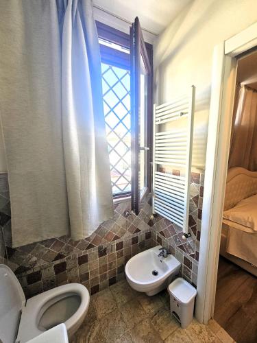 a bathroom with a toilet and a sink at Affittacamere Casa Brajan in Follonica