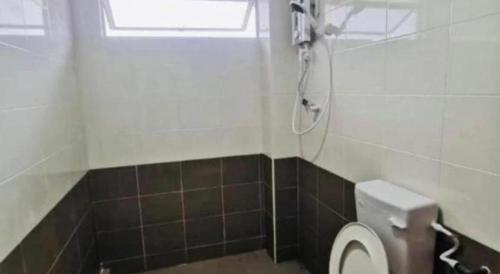 a bathroom with a toilet with a window and a shower at OYO 90507 Chalet Sumayyah in Melaka