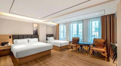 a hotel room with two beds and a table and chairs at GreenTree Inn Harbin Central Avenue in Harbin