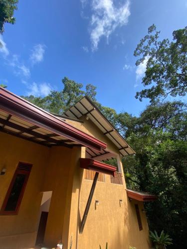 a house with a roof on top of it at River's Edge Resort Sinharaja in Kudawe