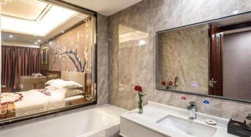 ein Bad mit einer Badewanne und ein Schlafzimmer in der Unterkunft Nan Guo Hotel in Guangzhou