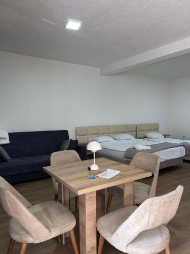 une pièce avec une table, des chaises et un lit dans l'établissement Beige Apartments, à Struga