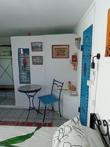 a room with a bed and a table and a chair at Dar Warda in Bizerte