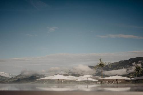 a group of umbrellas on a beach with clouds at Hotel Berghof - St Johann in Salzburg in Sankt Johann im Pongau